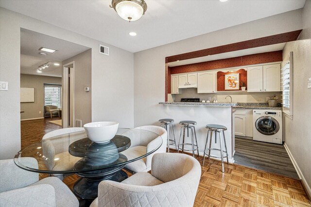 dining room featuring visible vents, washer / clothes dryer, and baseboards