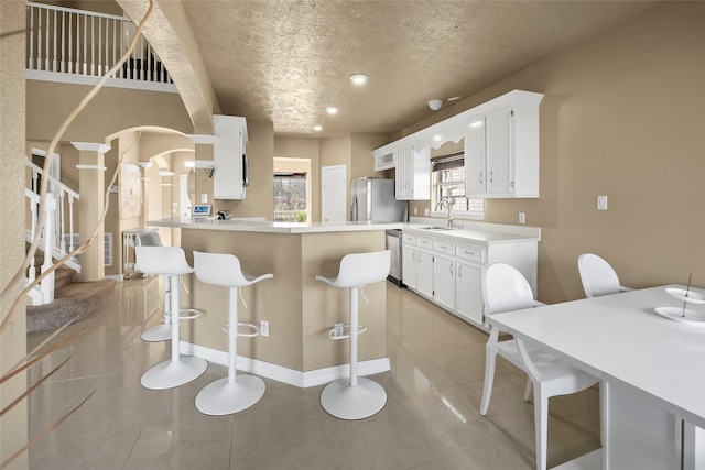 kitchen with sink, white cabinetry, plenty of natural light, and stainless steel appliances