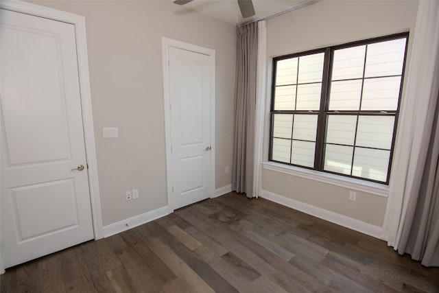 unfurnished bedroom with ceiling fan and dark wood-type flooring