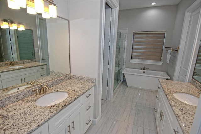 bathroom featuring vanity and independent shower and bath