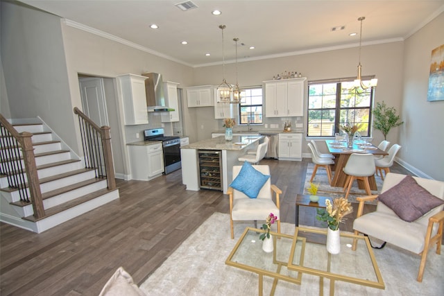 living room with a notable chandelier, sink, ornamental molding, dark hardwood / wood-style flooring, and wine cooler