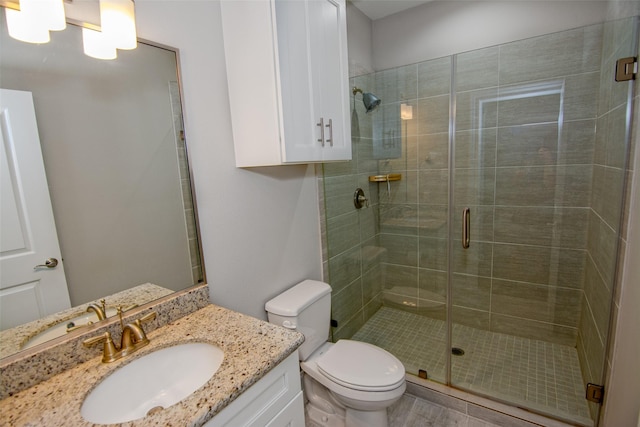 bathroom featuring toilet, an enclosed shower, and vanity