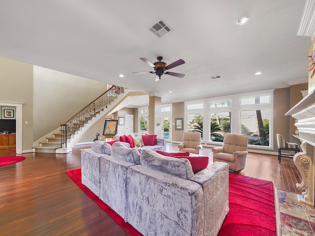 living room with decorative columns, plenty of natural light, a high end fireplace, and dark hardwood / wood-style flooring