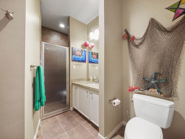 bathroom with a shower with shower door, toilet, vanity, and tile patterned flooring