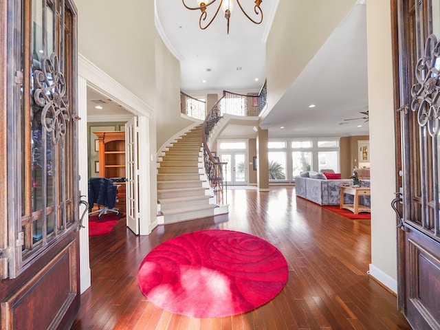 foyer featuring crown molding, an inviting chandelier, and dark hardwood / wood-style floors