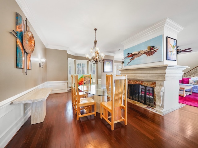 dining space with ceiling fan, ornamental molding, a fireplace, and hardwood / wood-style floors