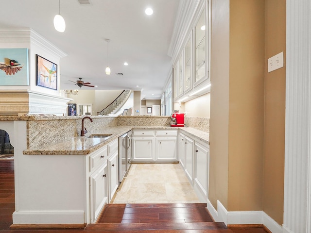 kitchen featuring sink, white cabinets, kitchen peninsula, and pendant lighting