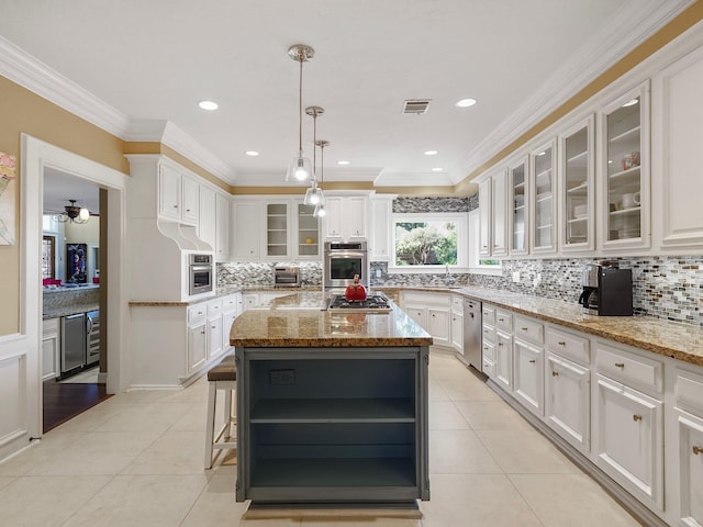 kitchen featuring light stone countertops, white cabinets, a kitchen island, stainless steel appliances, and light tile patterned flooring