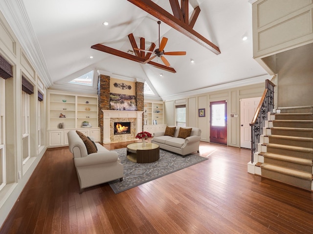 living room with a fireplace, built in features, wood-type flooring, and a wealth of natural light