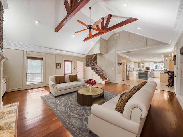 living room with hardwood / wood-style flooring, high vaulted ceiling, ornamental molding, and ceiling fan