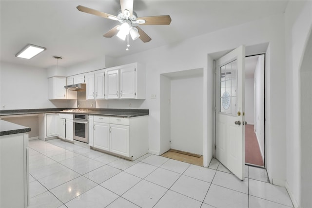 kitchen with light tile patterned floors, white cabinetry, oven, and ceiling fan