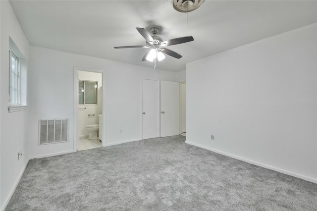 unfurnished bedroom featuring ceiling fan, connected bathroom, and light carpet