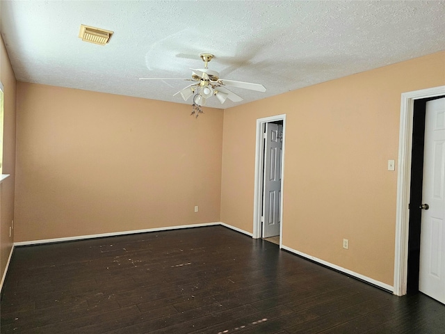 empty room with ceiling fan, dark hardwood / wood-style floors, and a textured ceiling