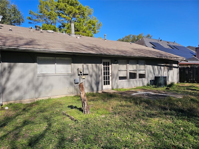 back of house featuring cooling unit and a lawn