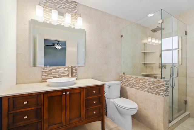 bathroom featuring a shower with shower door, toilet, tile walls, vanity, and backsplash