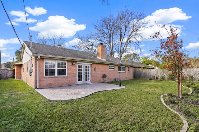 back of property with a patio area, a yard, and french doors