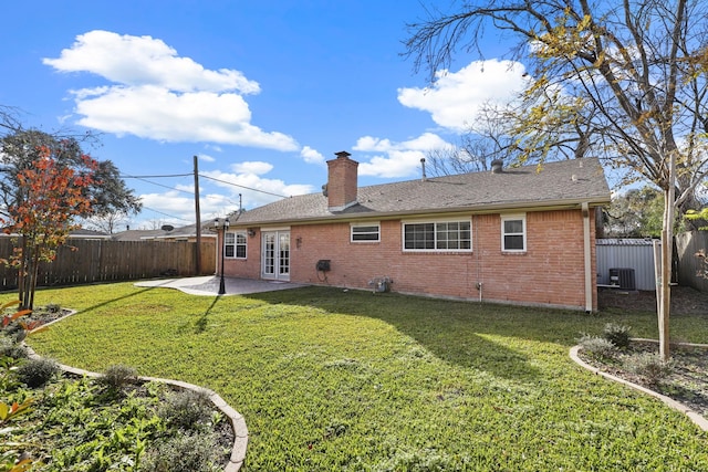 back of property with central AC unit, a lawn, french doors, and a patio