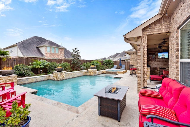 view of swimming pool featuring an in ground hot tub, a patio, ceiling fan, and an outdoor living space with a fire pit