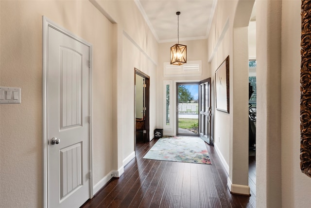 foyer with dark hardwood / wood-style flooring, a chandelier, and ornamental molding