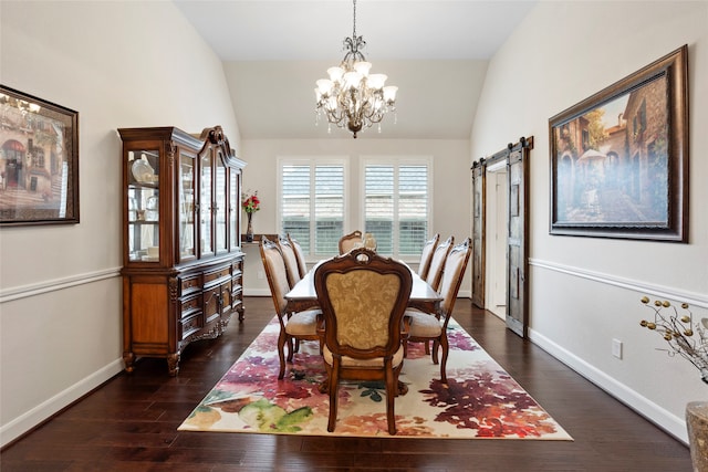 dining room featuring dark hardwood / wood-style flooring, an inviting chandelier, a barn door, and vaulted ceiling