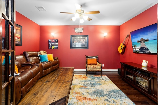 living room featuring ceiling fan and dark hardwood / wood-style flooring