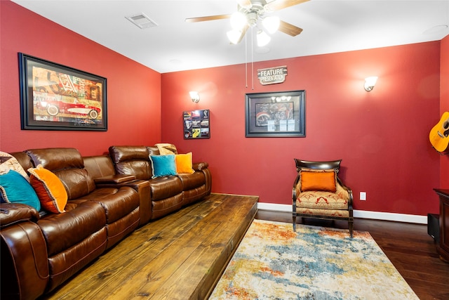 home theater room with ceiling fan and dark wood-type flooring