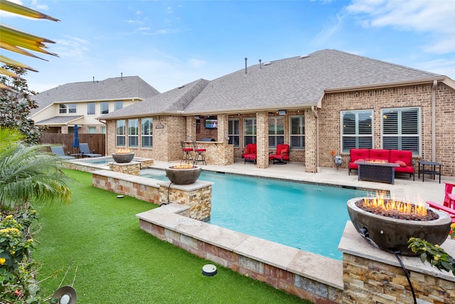 view of swimming pool with a patio area, a jacuzzi, and an outdoor living space with a fire pit