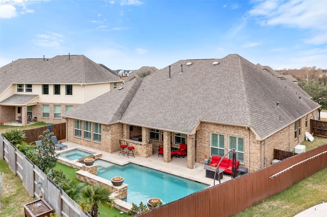 view of pool featuring an in ground hot tub, a patio, an outdoor living space with a fireplace, and a bar