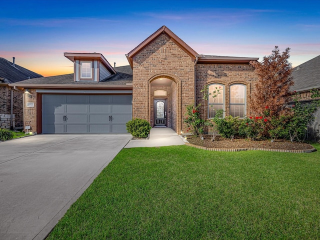 view of front of property featuring a garage and a yard