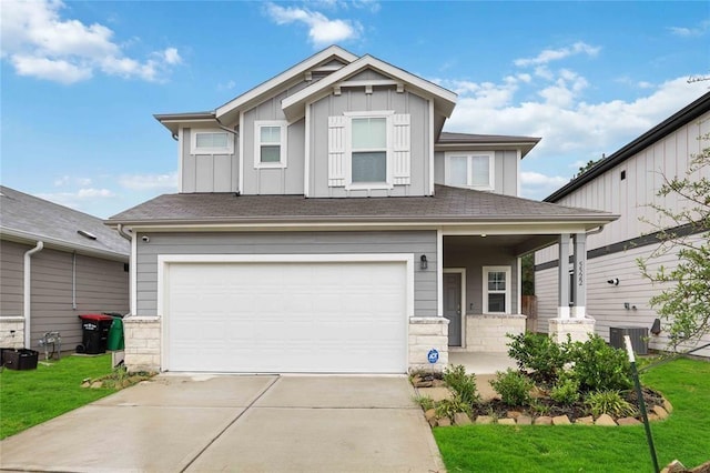 craftsman house featuring a porch, central AC, a garage, and a front lawn