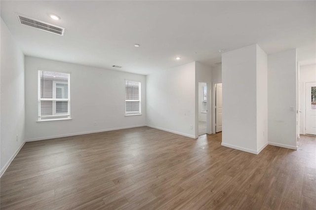 spare room featuring a healthy amount of sunlight and hardwood / wood-style floors