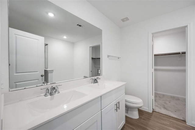 bathroom featuring vanity, hardwood / wood-style flooring, and toilet