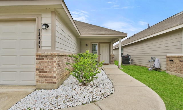 property entrance with a garage and central AC