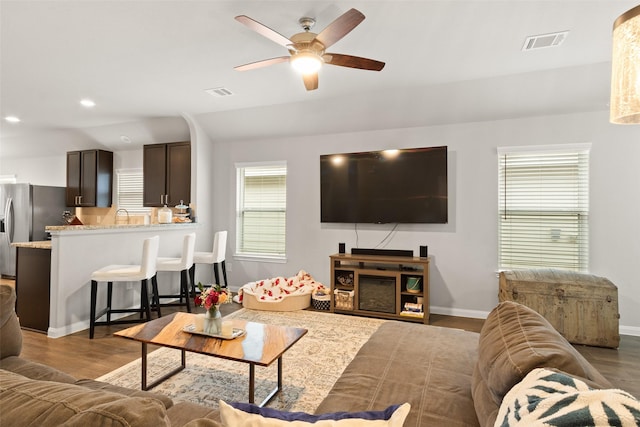 living room featuring ceiling fan, sink, dark hardwood / wood-style floors, and a wealth of natural light