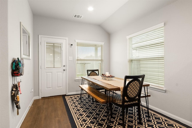 dining area featuring dark wood-type flooring and lofted ceiling