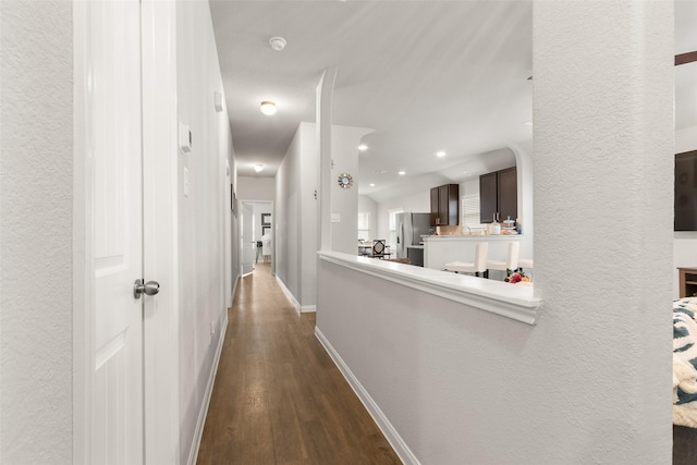 hallway featuring dark hardwood / wood-style floors and lofted ceiling