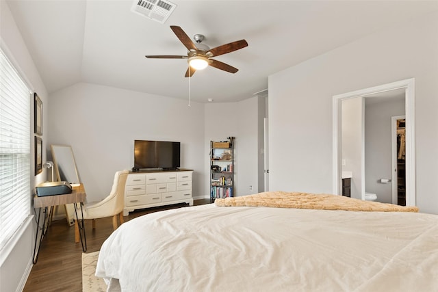 bedroom featuring ceiling fan, ensuite bathroom, multiple windows, and wood-type flooring