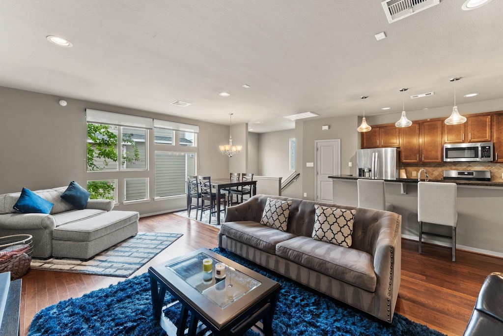 living room featuring an inviting chandelier and dark hardwood / wood-style flooring