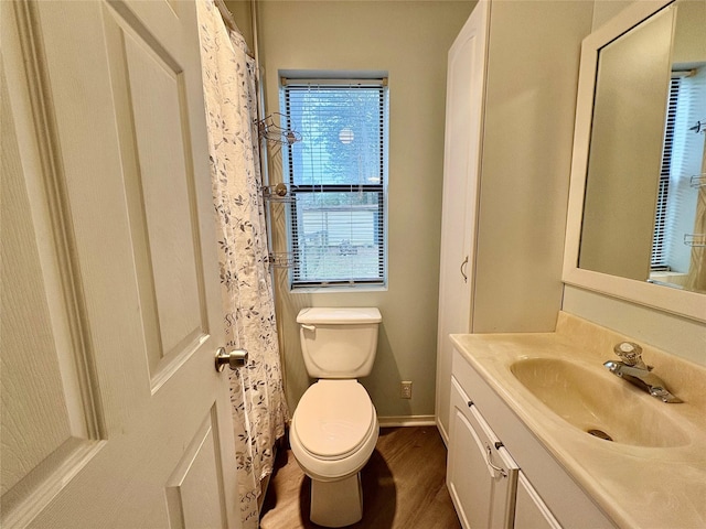 bathroom featuring wood-type flooring, toilet, and vanity