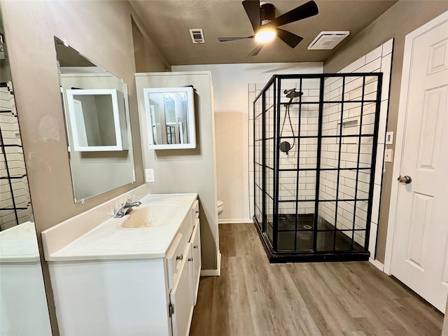 bathroom featuring toilet, a textured ceiling, vanity, ceiling fan, and hardwood / wood-style floors