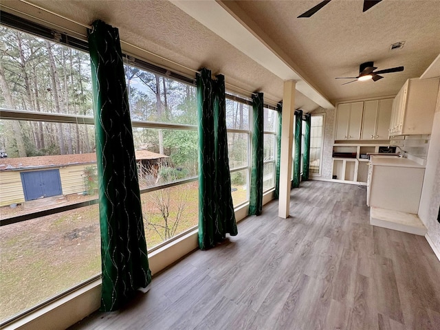 sunroom featuring ceiling fan