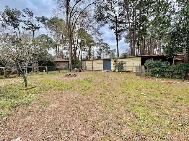 view of yard with an outdoor structure and an outdoor fire pit