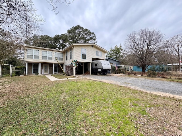 rear view of house featuring a carport, a yard, and covered porch