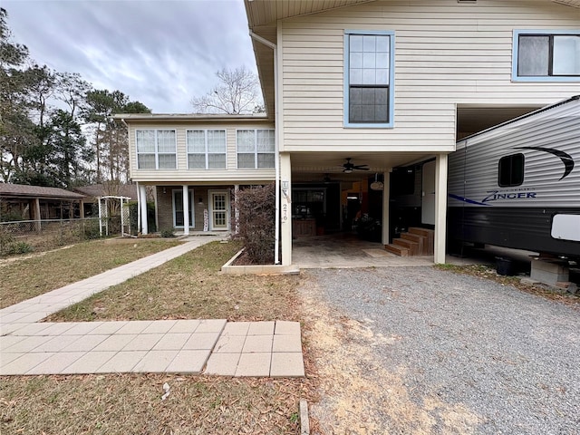 back of property featuring a carport and ceiling fan