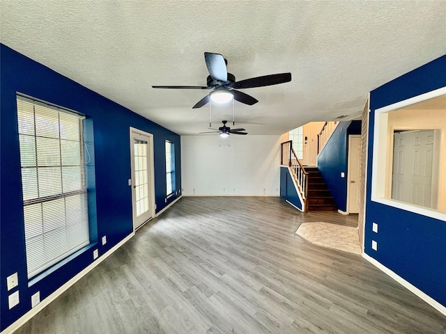 unfurnished room featuring ceiling fan, hardwood / wood-style flooring, and a textured ceiling