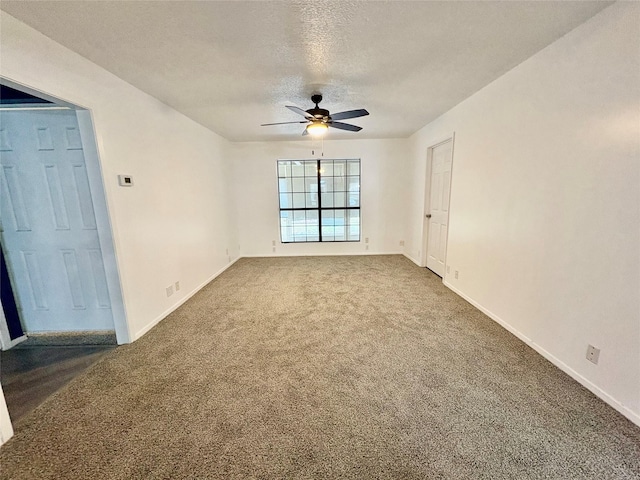 empty room featuring ceiling fan, carpet floors, and a textured ceiling