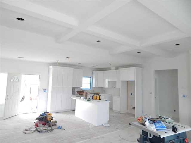 kitchen with coffered ceiling, a center island, beam ceiling, and white cabinetry