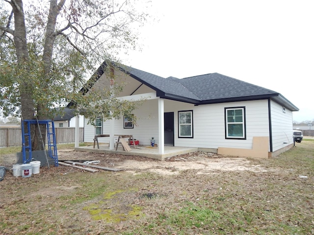 rear view of property featuring a trampoline and a patio