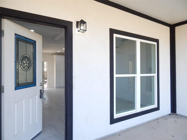 doorway to property featuring stucco siding