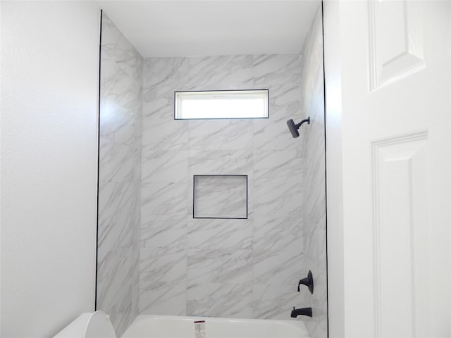 bathroom featuring washtub / shower combination and toilet